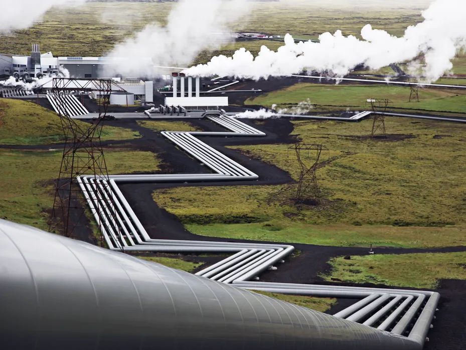 an aerial view of a geothermal power plant emitting steam in iceland