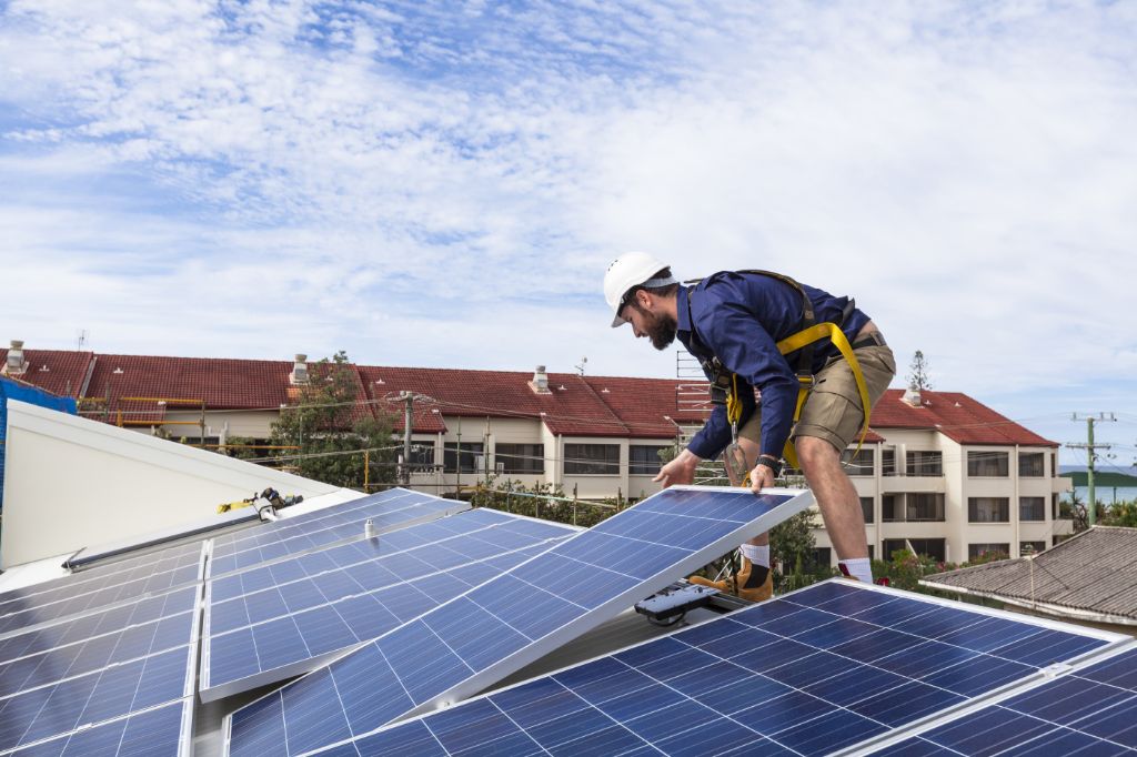 homeowner installing solar panels on roof