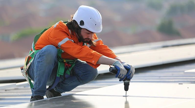 workers removing solar panels from a roof.