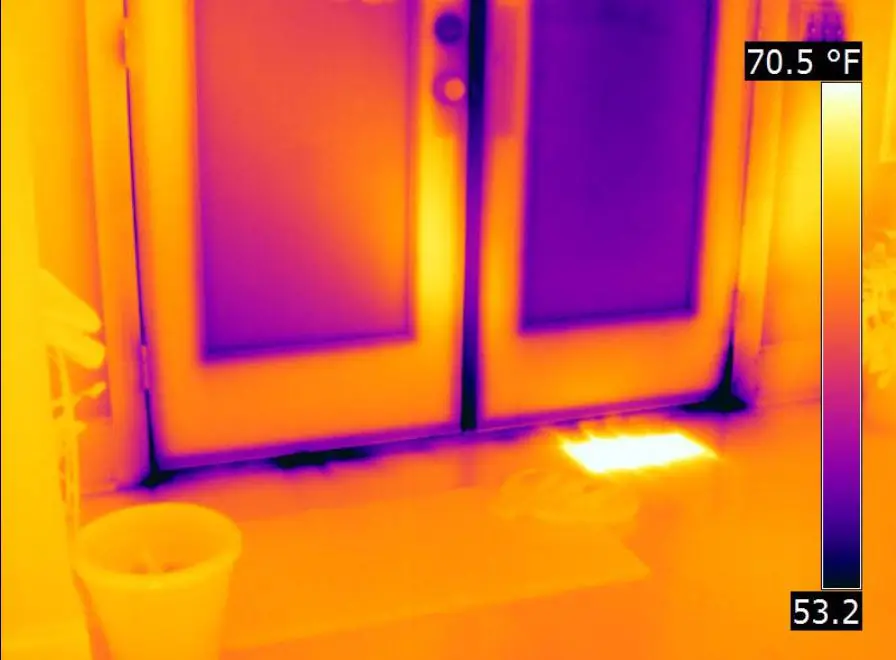 a person using infrared camera to detect heat leakage in a building to improve energy efficiency