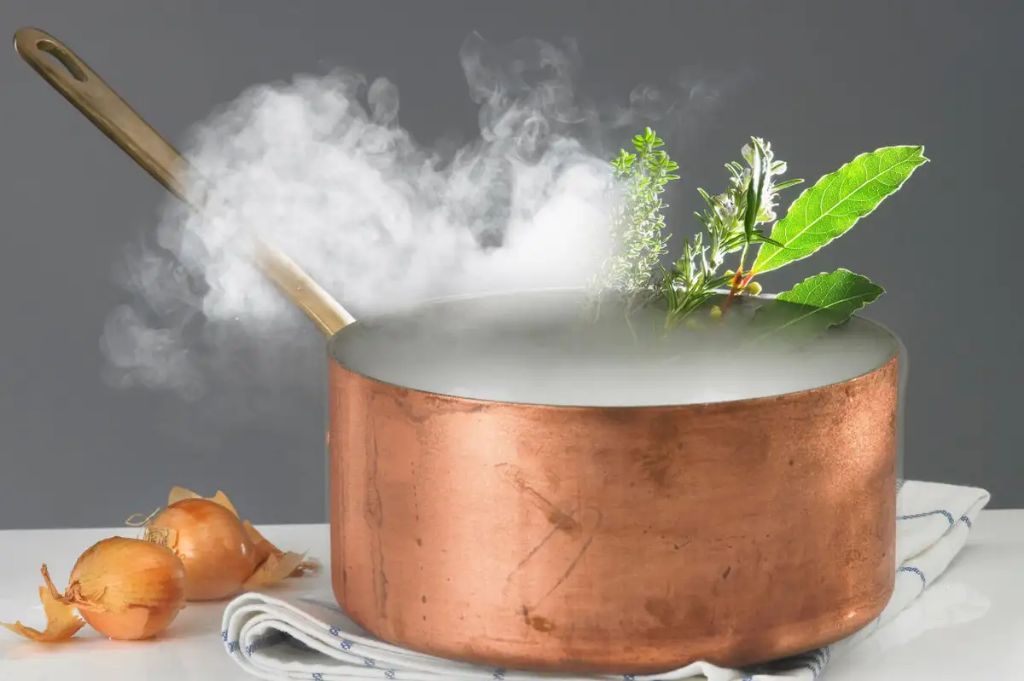 a pot of water boiling and releasing steam 